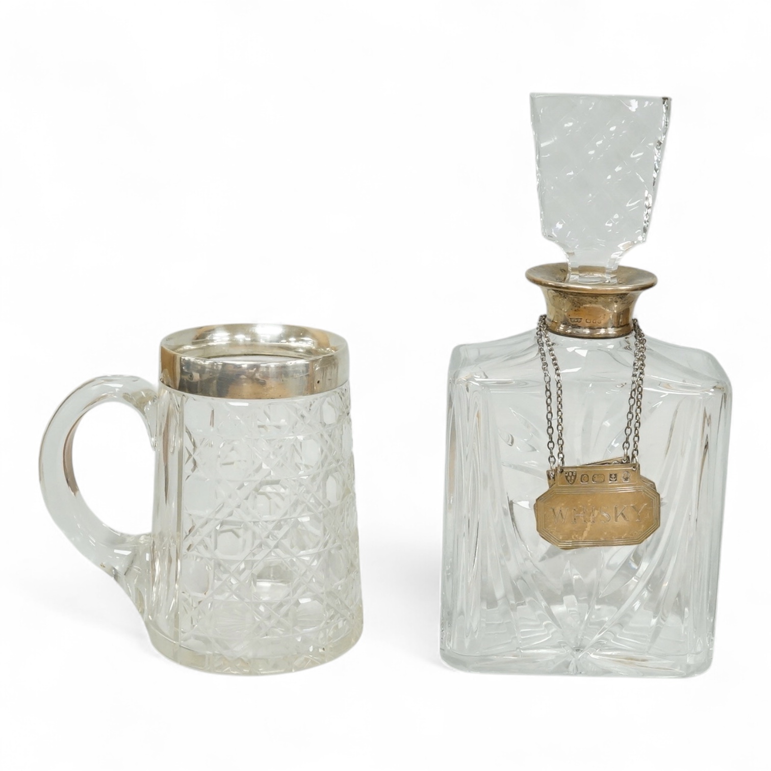 A late Victorian silver mounted cut glass mug, Saunders & Shepherd, Chester, 1899, height 13.4cm, together with a modern silver mounted cut glass decanter and a modern pair of silver 'Whisky' and 'Brandy' wine labels, J.
